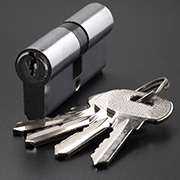 a euro lock standing next to a set of keys on a grey backdrop
