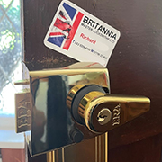a night latch lock with Brtiannia Locksmith's business card sitting on top